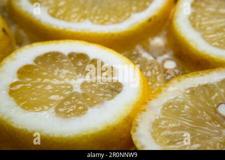 macro primo piano della fetta di limone giallo, salute e benessere, dieta, ideale per limonata, acqua di limone, detox, cibo acidulo, succoso, Foto Stock