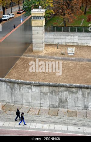 Berlino, Germania: Si affaccia su una parte conservata del muro di Berlino che mostra la "striscia della morte" e la torre di guardia. Foto Stock