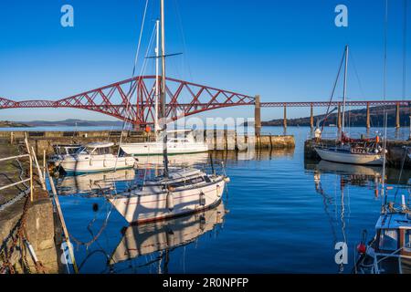 Barche ormeggiate nel porto di South Queensferry con lo sfondo di Forth Rail Bridge - South Queensferry, Scozia, Regno Unito Foto Stock