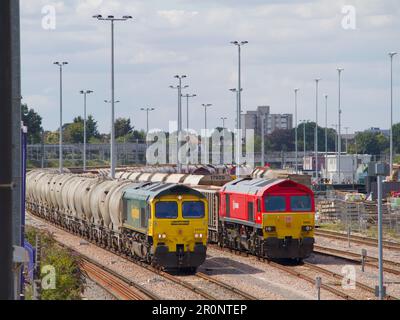 Classe Freightliner Classe 66 numero 66605 serbatoi di cemento vuoti che passano DB Cargo UK Classe 59 numero 59205 con un treno di pietre caricato. Cantiere di Acton. Foto Stock