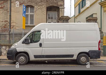 Pulmino di consegna bianco parcheggiato a Street in City Foto Stock