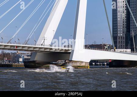 Vista sul fiume Maas a Rotterdam, nei Paesi Bassi, verso una piccola barca che spruzzi d'acqua lateralmente in acque frastolose Foto Stock