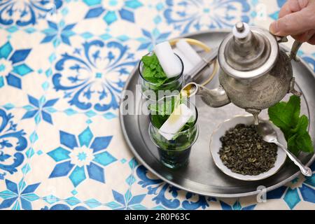 Tradizionale tè marocchino alla menta e allo zucchero con teiera d'argento Foto Stock