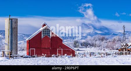 Il fienile rosso brillante Stroh/Dickens e un mulino a vento dal Centro del Patrimonio agricolo, con il picco dei Longs sullo sfondo, a Longmont, Colorado. Foto Stock