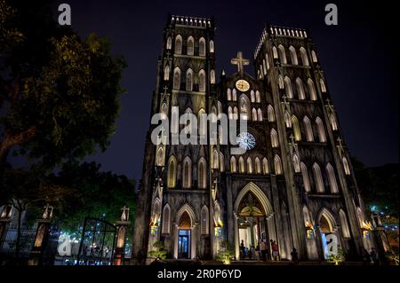 Una Cattedrale illuminata di San Giuseppe, simile a Notre Dame a Parigi, di notte nel centro di Hanoi, Vietnam. Foto Stock