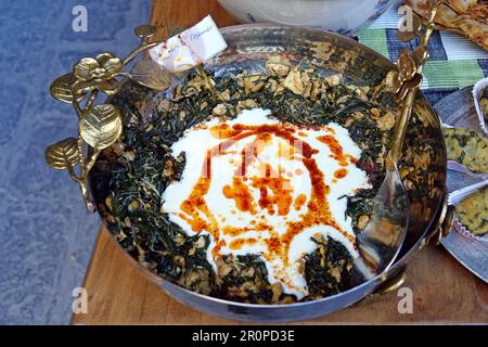 3 maggio 2023, Diyarbakir, tacchino: Si vede un piatto con salsa di yogurt fatta con erbe aromatiche. Filiz Parlak, una Gastronomia Gastronomia a Diyarbakir, ha organizzato un Concorso di alimenti alle erbe naturali. Al fine di promuovere le erbe coltivate nei giardini Hevsel del patrimonio culturale mondiale e gli alimenti fatti con queste erbe, sono stati preparati 41 tipi di cibo da 21 tipi di erbe. Tra gli alimenti e le bevande erano cibi dolci fatti da queste erbe, sottaceti, marmellate, biscotti, delizie turche, Caffè, tè, Decanters, pane. Nel concorso tenutosi nello storico Palazzo di Zerzevan, i membri della giuria hanno assaggiato 21 tipi di fo Foto Stock