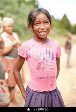 Tsiafahy, Madagascar - 25 aprile 2019: Piccola ragazza in maglietta rosa donata dai turisti che sorridono in macchina fotografica. Persone in Madagascar, soprattutto malgascio Foto Stock