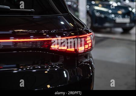 Riga, Lettonia, 28 aprile 2023: Luci posteriori a LED primo piano del suv elettrico nev VW ID4, modello 2023, elegante design esterno di nuova vettura Foto Stock