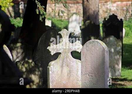SIDMOUTH, DEVON, Regno Unito - 21 MARZO 2017 luce del sole e ombre estive nel cortile della chiesa di Sidmouth Parish Church grave pietre Foto Stock
