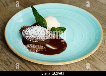 Soufflé al cioccolato con salsa di fragole e gelato alla vaniglia Foto Stock