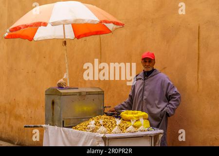 Marrakech, Marocco - 05 aprile 2023: Vista di un vicolo con un venditore e il suo stallo, nella Medina di Marrakech, Marocco Foto Stock