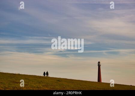 Sulla diga con vista sul faro di Den Helder (luna nel cielo) Foto Stock