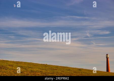 Sulla diga con vista sul faro di Den Helder (luna nel cielo) Foto Stock