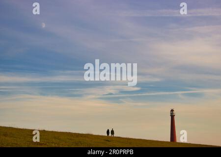 Sulla diga con vista sul faro di Den Helder (luna nel cielo) Foto Stock