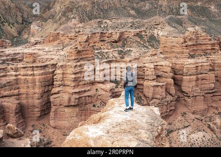 Giovane donna che si affaccia sul canyon di Charyn nel Kazakistan sudorientale nella regione di Almaty. Tian Shan montagne. Foto Stock