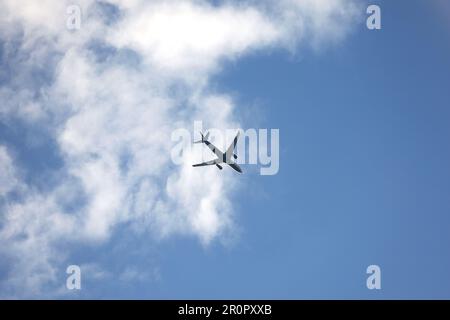 Silhouette di aeroplano che vola in cielo con nuvole bianche. Aereo passeggeri in volo, concetto di viaggio Foto Stock