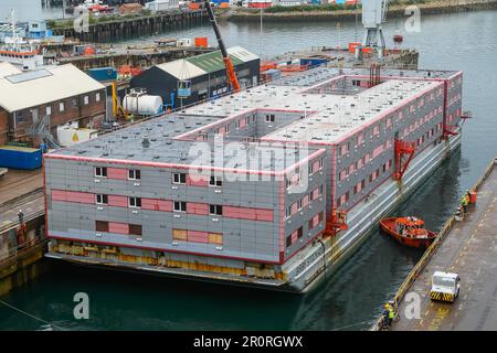 Falmouth, Cornovaglia, Regno Unito. 9th maggio 2023. La chiatta dell'alloggio Bibby Stockholm che è stata trainata dal Tug Sea Dream, Arriva a Falmouth in Cornovaglia da Genova in Italia per la manutenzione e le ispezioni di sicurezza nella darsena prima di essere trasferito al porto di Portland vicino a Weymouth in Dorset nel mese di giugno, dove ospiterà fino a 500 richiedenti asilo per 18 mesi. Picture Credit: Graham Hunt/Alamy Live News Foto Stock