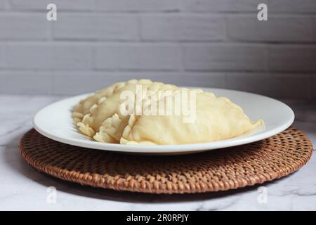 Pastel Goreng è una pasticceria popolare in Indonesia. pastelli crudi pronti per la cottura ripieni di verdure e carne di pollo Foto Stock