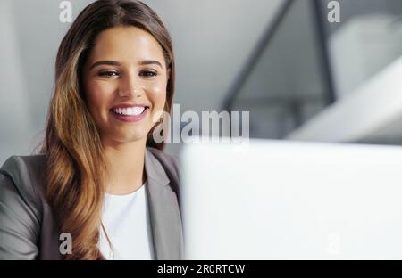 In ascesa a livelli ineguagliabili nella sua carriera. una giovane donna d'affari che lavora su un computer portatile in ufficio. Foto Stock