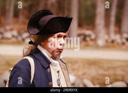 Lexington, Massachusetts USA - Aprile 2023 - un attore di abbigliamento coloniale fischia mentre cammina lungo Battle Road nel Minuteman National Historical Foto Stock