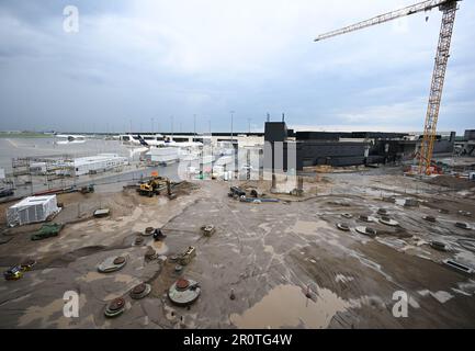 PRODUZIONE - 09 maggio 2023, Hesse, Francoforte sul meno: Una gru da cantiere sale nell'aria tra Piers G (sullo sfondo) e H presso il cantiere del Terminal 3 dell'aeroporto di Francoforte. I lavori per il nuovo Terminal 3 dell'aeroporto più grande della Germania sono in piena fase. L'intera sezione sarà operativa nel 2026. Foto: Arne Dedert/dpa Foto Stock