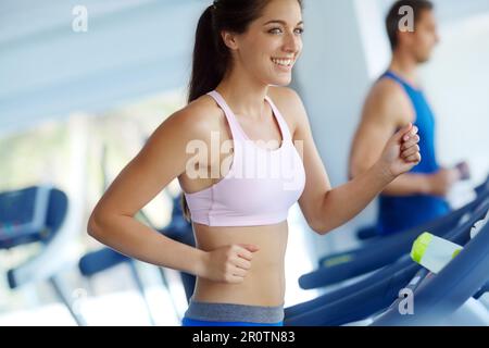 Il passo successivo per il fitness. Un giovane uomo e una donna che si allenano sulle pedane mobili in palestra. Foto Stock