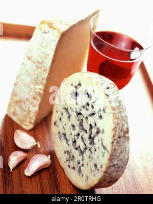 Formaggi, bicchiere di vino rosso e aglio Foto Stock