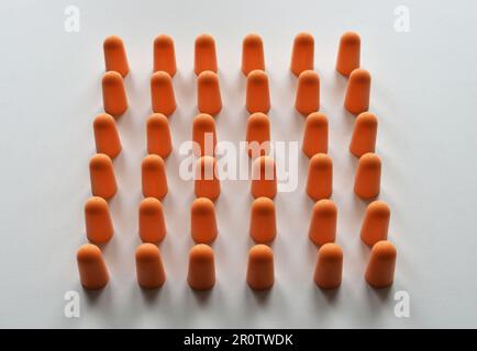 Tappi auricolari in schiuma arancione isolati su sfondo bianco Foto Stock