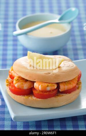 Panino in bagel di gamberetti, curry e pomodoro Foto Stock