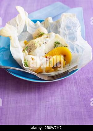 Merluzzo con frutta esotica cotta in carta cera Foto Stock