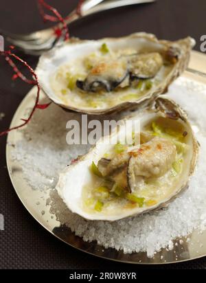 Ostriche grigliate con porri morbidi e parmigiano Foto Stock