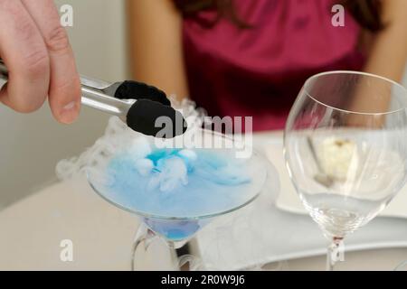 Preparare e servire un cocktail con ghiaccio secco Foto Stock