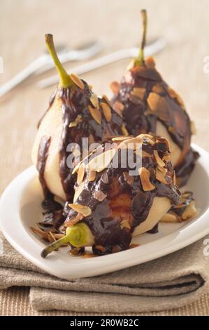 Stufati di pere con salsa al cioccolato e affettate finemente le mandorle Foto Stock