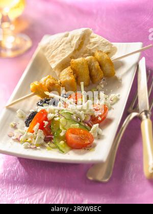 Brchette di pollo alla griglia, insalata greca e pitta Foto Stock