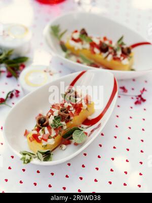 Polenta con pomodori, mozzarella, capperi e acciughe Foto Stock