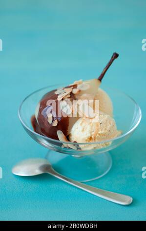 Pera stufata con salsa al cioccolato e gelato alla vaniglia Foto Stock