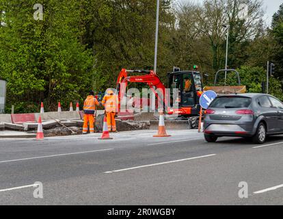 Castlereagh, Belfast County Down, Irlanda del Nord, aprile 26 2023 - due operai che guardano un altro uomo che lavora un scavatore meccanico Foto Stock