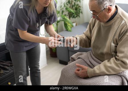 Misurazione del livello di ossigeno e della frequenza del polso con un pulsossimetro portatile - un uomo monitora la sua salute Foto Stock