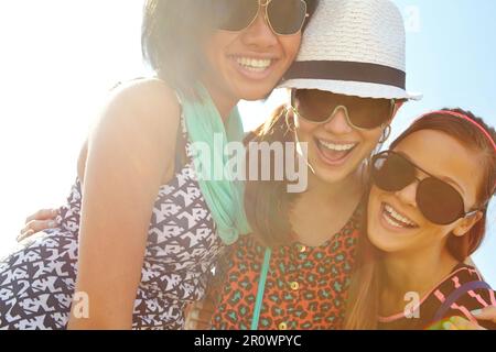 Tre di un genere. Primo piano di un gruppo di ragazze adolescenti sorridenti con le braccia intorno alle spalle. Foto Stock