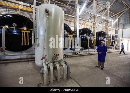 Provincia di Jambyl, Kazakistan - 24 aprile 2012: Impianto di biogas moderno. Reattori e forni per serbatoi di gas. Operatore in abbigliamento da lavoro blu Foto Stock