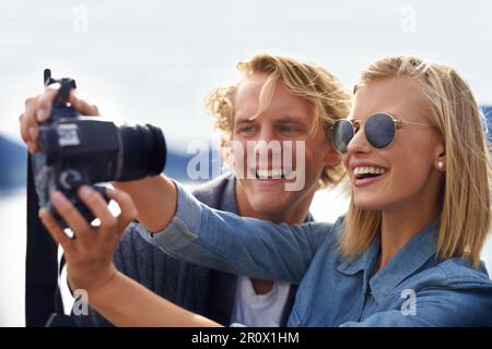 Cattura i momenti di amore nei grandi spazi aperti. Un'immagine di una giovane coppia che fa un autoritratto in un viaggio su strada. Foto Stock