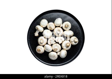 Funghi crudi champignon su un piatto. Isolato su sfondo bianco Foto Stock