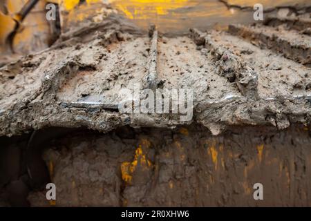 Foto di primo piano dei cingoli di guida dell'apripista sporchi Foto Stock