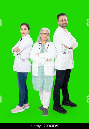 Team di medici indiani in piedi croce braccia isolate su sfondo verde studio, sanità e concetto medico. spazio di copia. Foto Stock