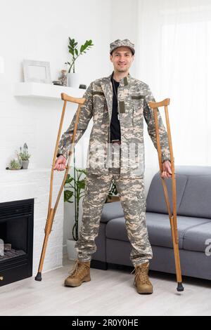 soldato in uniforme militare cachi su stampelle Foto Stock