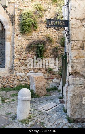 Vista verticale del vecchio stile servizi igienici pubblici o urinoir (portoghese: Urinol) per l'uomo con segnaletica in ferro costruito nelle mura storiche del Palazzo Belmonte Foto Stock