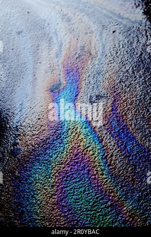 Chiazza di olio colorata sull'asfalto, sfondo astratto Foto Stock