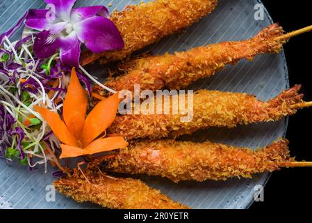 Gamberi fritti in pastella con salsa rossa isolato su sfondo nero vista dall'alto Foto Stock