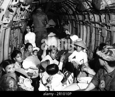 Storditi dalla vistosità di un attacco Viet Cong al loro villaggio, i rifugiati di guerra del Vietnam cavalcano un elicottero dell'aeronautica statunitense verso un'area sicura vicino Saigon. Marzo 1966. Foto Stock