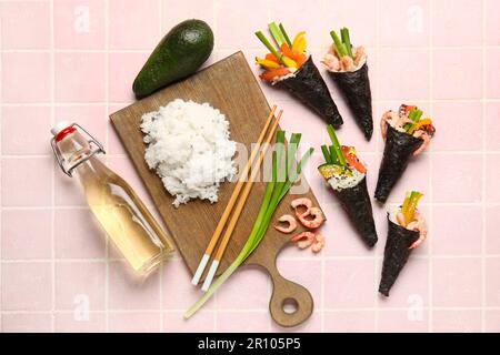 Composizione con gustosi coni di sushi e ingredienti su sfondo piastrellato colorato Foto Stock